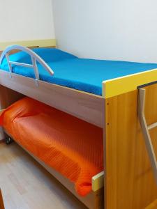 a bunk bed in a room with an orange and blue mattress at Apartments Beti in Poreč