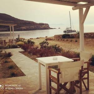 a white table and chairs on a beach at Sunset Studios & Rooms in Antiparos