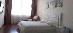 1 dormitorio con 1 cama, 1 silla y 1 ventana en Альтаир1, en Odessa