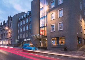 un coche azul estacionado frente a un edificio en Apex City of Edinburgh Hotel, en Edimburgo