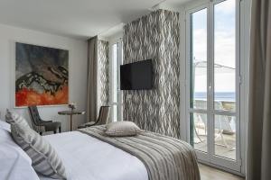a hotel room with a bed and a television on a wall at Sublimis Boutique Hotel Adults-Only in Camogli