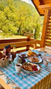 een tafel met ontbijtproducten op een blauw gecontroleerd tafelkleed bij Wooden House Ripac in Bihać