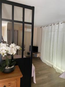 een kamer met een spiegel en een tafel met een vaas met bloemen bij villa donia in Corte