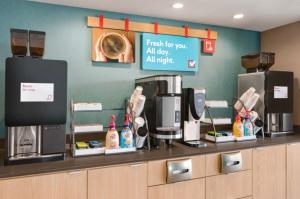 a coffee shop with a counter with a coffee machine at AVID Hotels Corpus Christi - Portland, an IHG Hotel in Portland
