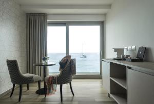 a room with a table and chairs with a view of the ocean at Sublimis Boutique Hotel Adults-Only in Camogli