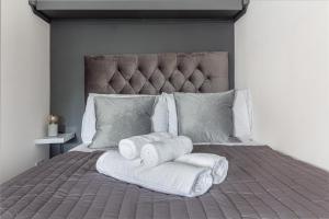 ein Bett mit Handtüchern darauf gestapelt in der Unterkunft Guest Homes - New Street Accommodation in Worcester