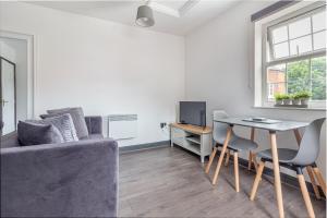 ein Wohnzimmer mit einem Sofa und einem Tisch in der Unterkunft Guest Homes - New Street Accommodation in Worcester