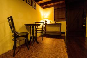 a small table and chairs in a room with a desk at Arun Residence in Bangkok