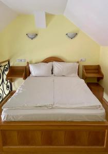 a bed with white sheets and pillows in a room at Casa Irlandeza - Irish House in Baile Felix