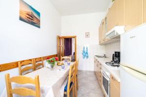 cocina con mesa con sillas y mesa en Apartments Kazo, en Dubrovnik