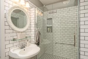 La salle de bains blanche est pourvue d'un lavabo et d'un miroir. dans l'établissement Moulin Rouge House Bed and Breakfast, à Mankato