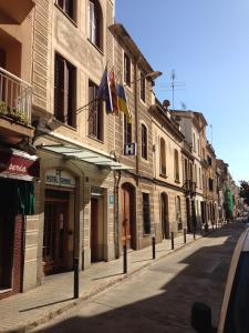 an empty street with buildings with flags on the fronts at Hotel Torino in Masnou