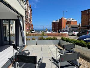Dos sillas y una sombrilla en un patio. en 10 Argyle Court, en Whitby