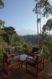 una terraza con sillas, mesa y vistas en Kaliwa Lodge, en Moshi