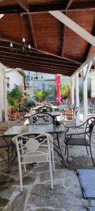 Guest House Palazzo في بايالا: مجموعة من الطاولات والكراسي على الفناء