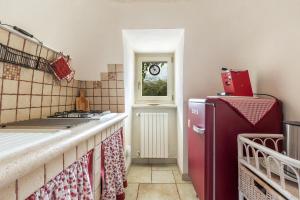 uma cozinha com um frigorífico vermelho e um fogão em Trullo Ventura by BarbarHouse em Locorotondo