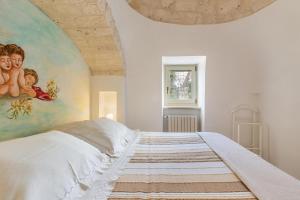 um quarto com uma cama grande e uma pintura na parede em Trullo Ventura by BarbarHouse em Locorotondo