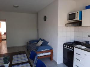 a small kitchen with a couch and a microwave at Departamento Céntrico Las Estaciones in Sunchales