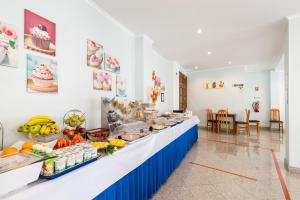 a buffet line in a room with fruits and vegetables at Hotel Residencial Colibri in Costa da Caparica