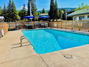 a swimming pool with blue water in a yard at Ashland Motel - Oregon in Ashland