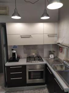 a kitchen with a stove and a sink and lights at Castagna Apartment Letojanni - Taormina in Letojanni