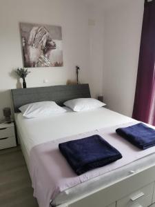 a bedroom with a large bed with two towels on it at M&M`s- lovely apartments in Baška Voda