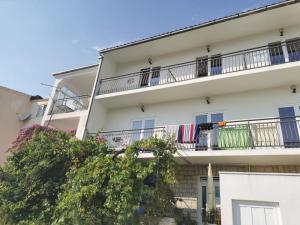 an apartment building with balconies and a tree at M&M`s- lovely apartments in Baška Voda