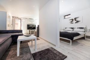 a living room with a couch and a bed at Trys Apartamentai in Palanga