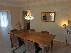 a dining room with a wooden table and a chandelier at Ferienwohnung Jill Schleiden in Schleiden