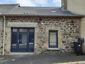 a stone building with blue doors and a gray roof at Le Bouchatou (meublé touristique neuf)*** in Saint-Front +5 photos