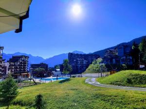 a view of a resort with a swimming pool and mountains at Chalet Côté Cœur, La Tania, with Outdoor Hot Tub and 7 Ensuite Rooms in La Tania +18 photos