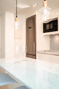 twee wijnglazen op een wit aanrecht in een keuken bij Polo Apartments 2A in Marbella