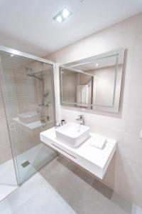 een witte badkamer met een wastafel en een douche bij Polo Apartments 2A in Marbella