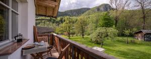 a balcony with a table and a view of the mountains at Apartma in sobe PR'OBJAN in Bohinj