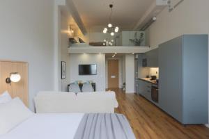 1 dormitorio con 2 camas blancas y cocina en Foundry Hotel Apartments en Uppsala