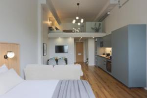 a bedroom with two white beds and a kitchen at Foundry Hotel Apartments in Uppsala