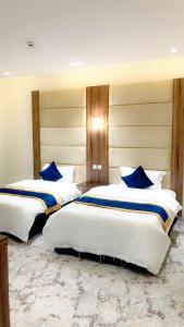 een slaapkamer met 2 bedden en blauwe kussens bij Golden Inn in Khamis Mushayt