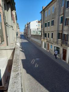 a person walking down a street next to buildings at Casa Alice in Chioggia