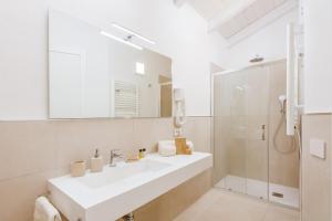 a white bathroom with a sink and a shower at La Vinia Bed&Wine Experience - Adults Only in Sassari