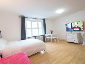 a bedroom with a bed and a tv on a wall at Luna 218 flat 3 at Marble Arch in London