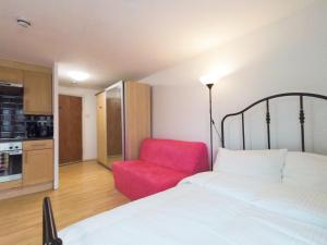 a bedroom with a bed and a red chair at Luna 218 flat 3 at Marble Arch in London