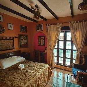 a bedroom with a bed and a large window at Hotel Boutique Casona Maya Mexicana in Tapachula