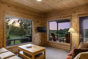 una sala de estar con una gran ventana en una cabaña de madera en This is the ultimate in private escape, en Ponca