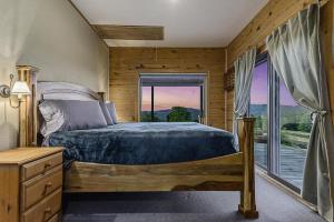 a bedroom with a bed and a large window at This is the ultimate in private escape in Ponca