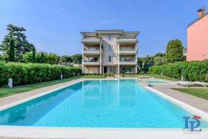 an image of a swimming pool in front of a building at Oscar Luxury Suite DesenzanoLoft Official Partner Homes & Villas by Marriott Bonvoy in Desenzano del Garda