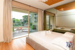 デセンツァーノ・デル・ガルダにあるMarriott Oscar Luxury Suite DesenzanoLoft Official Partner Homes & Villas by Marriott Bonvoyの大きな白いベッドとバルコニーのある寝室