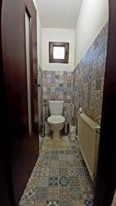 baño con aseo, ventana y azulejos en Vila Devana en Javorina