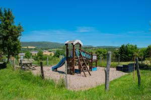 a playground with a slide in the sand at Sev'hotel in Sévérac-le-Château