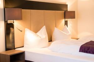 um quarto de hotel com uma cama com almofadas brancas em Goethe Business Hotel by Trip Inn em Frankfurt