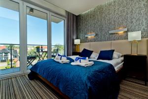 ヤスタルニャにあるBlueApart Marina Jastarniaのベッドルーム(青いベッド1台、大きな窓付)